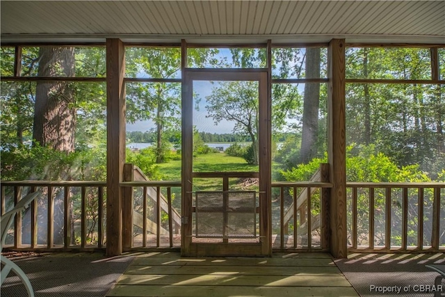 unfurnished sunroom featuring a water view and a healthy amount of sunlight