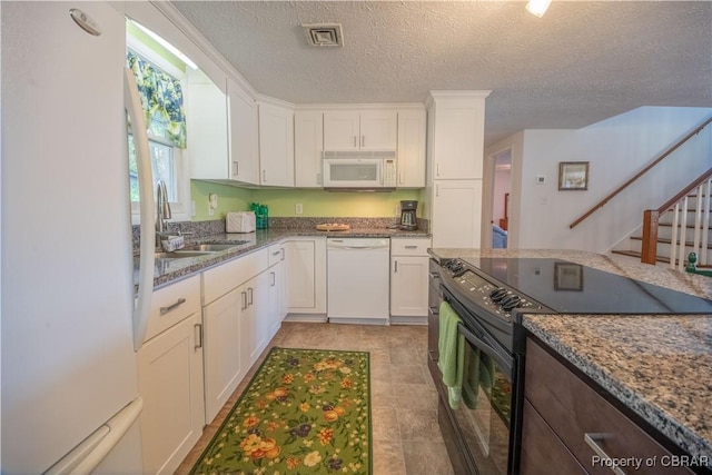 kitchen with stone counters, white cabinetry, sink, a textured ceiling, and white appliances