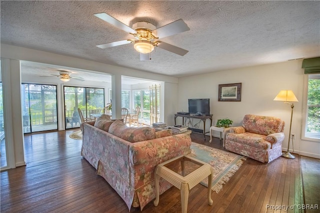 living room with a textured ceiling, dark hardwood / wood-style floors, and ceiling fan