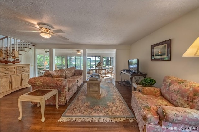 living room with ceiling fan, dark hardwood / wood-style flooring, and a textured ceiling