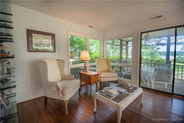 living area featuring a textured ceiling and hardwood / wood-style flooring