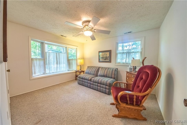 sitting room featuring carpet flooring, a textured ceiling, and ceiling fan