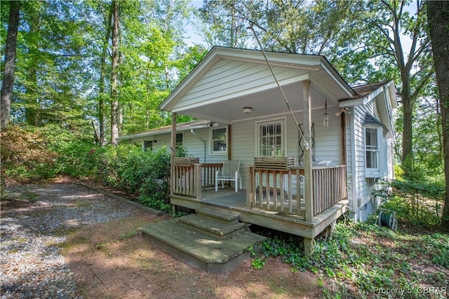 rear view of property featuring covered porch