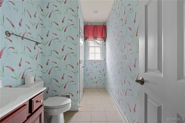 bathroom featuring toilet, vanity, tile patterned flooring, baseboards, and wallpapered walls