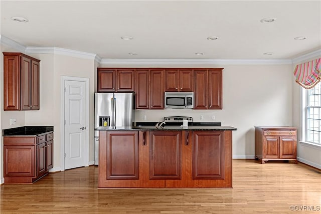 kitchen featuring light hardwood / wood-style floors, a center island, ornamental molding, and appliances with stainless steel finishes