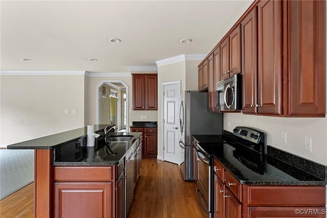 kitchen featuring hardwood / wood-style floors, sink, ornamental molding, an island with sink, and appliances with stainless steel finishes