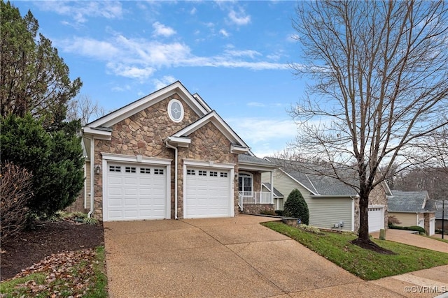 view of front of home with stone siding, an attached garage, and driveway