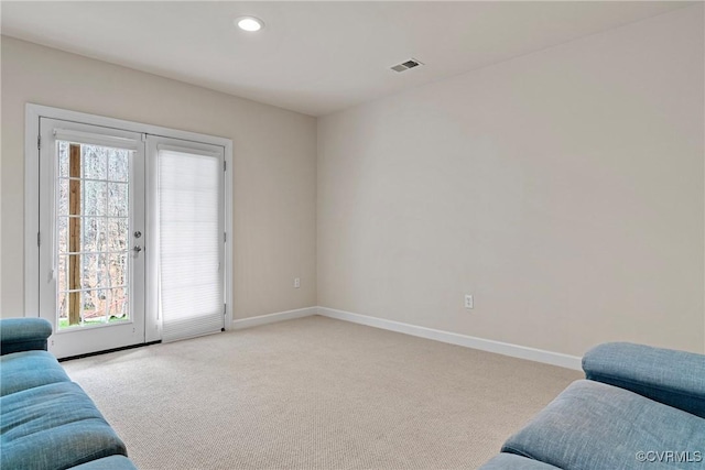 living room featuring visible vents, light carpet, and baseboards