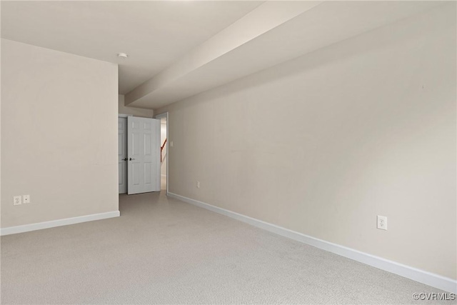 spare room featuring carpet and baseboards