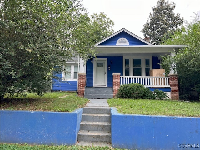 bungalow-style home featuring a porch and a front lawn