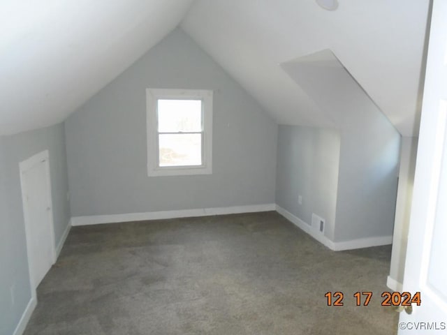 additional living space featuring lofted ceiling and light carpet