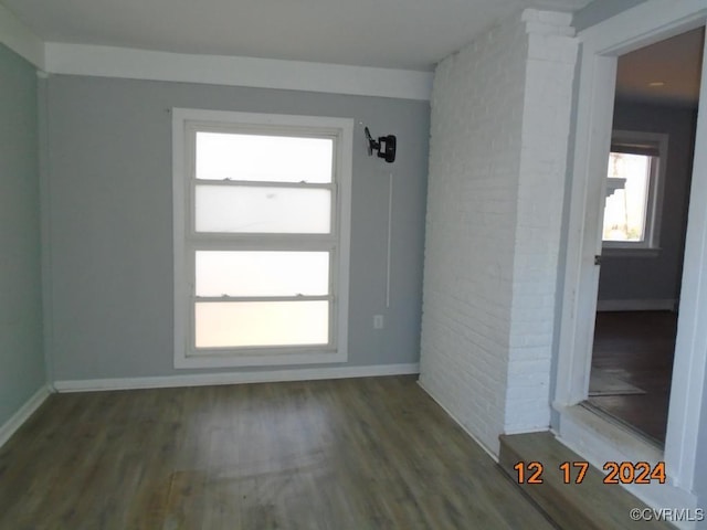 unfurnished room featuring decorative columns and hardwood / wood-style floors