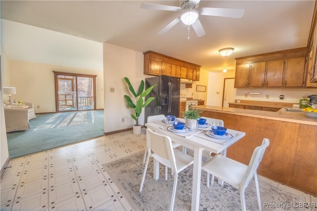 kitchen featuring kitchen peninsula, stainless steel fridge, ceiling fan, sink, and white stove