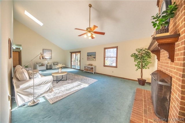 living room featuring a skylight, ceiling fan, high vaulted ceiling, carpet floors, and a fireplace