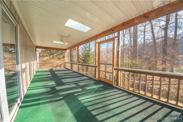 unfurnished sunroom with a skylight and ceiling fan