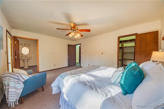 carpeted bedroom featuring ensuite bathroom, sink, ceiling fan, a spacious closet, and a closet