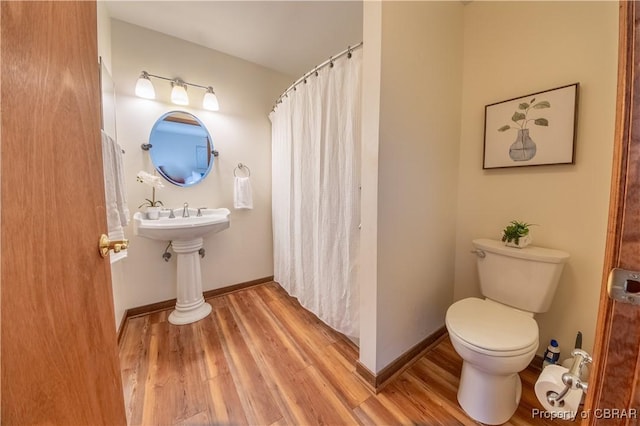 bathroom with wood-type flooring and toilet