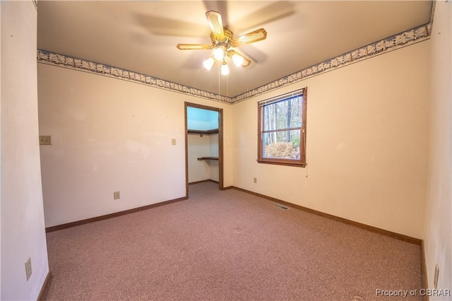 carpeted spare room with ceiling fan