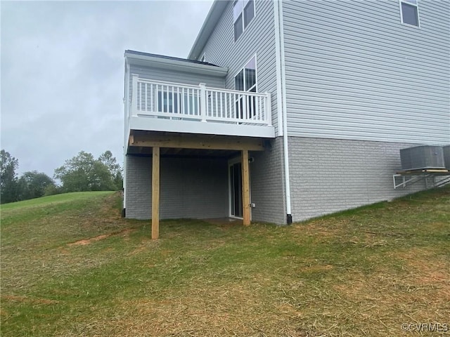 view of side of property with a lawn, a wooden deck, and cooling unit