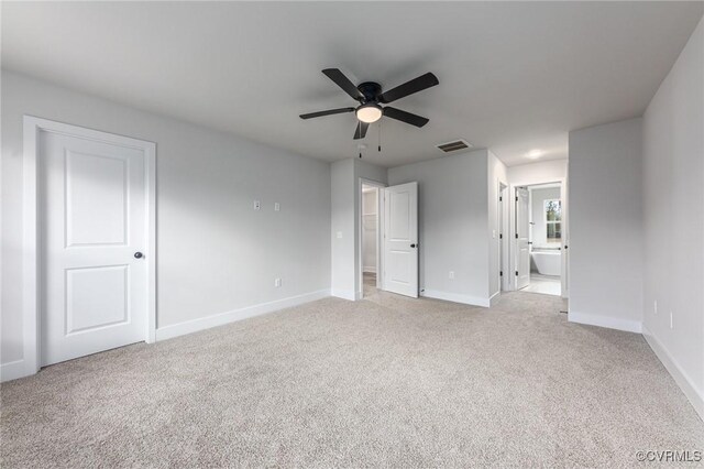 unfurnished bedroom featuring ensuite bathroom, ceiling fan, and light carpet