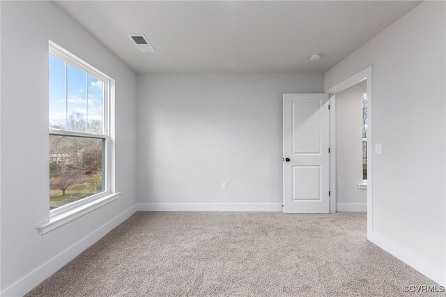 carpeted spare room with plenty of natural light