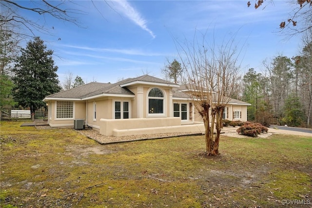 view of front of home with a front lawn and central AC unit