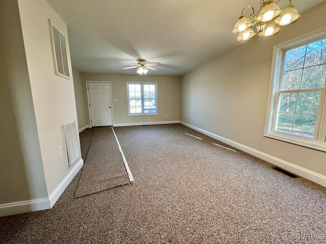 carpeted spare room with a healthy amount of sunlight and ceiling fan with notable chandelier