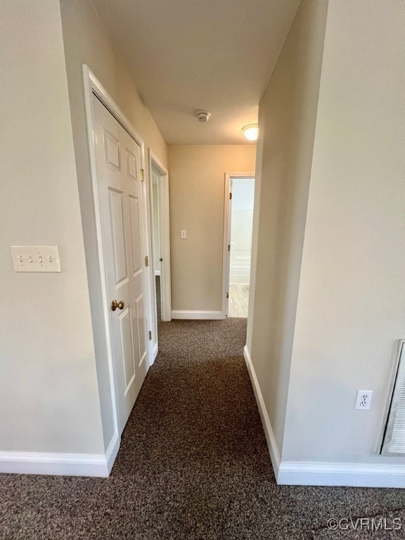 hallway with dark colored carpet