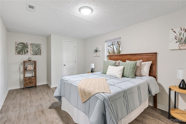 bedroom featuring a textured ceiling and light wood-type flooring