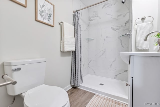 bathroom featuring hardwood / wood-style flooring, a shower with curtain, toilet, and vanity