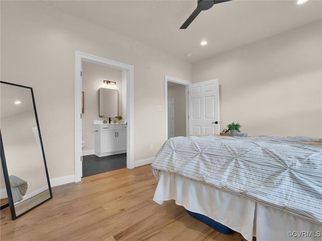 bedroom with connected bathroom, light hardwood / wood-style flooring, and ceiling fan