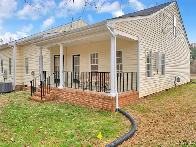 view of front of property with cooling unit and a front lawn