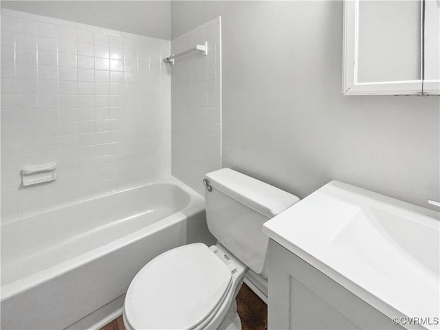 full bathroom featuring vanity, tiled shower / bath combo, and toilet