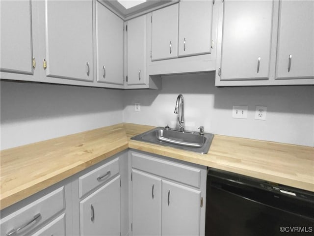 kitchen featuring butcher block countertops, gray cabinets, sink, and black dishwasher