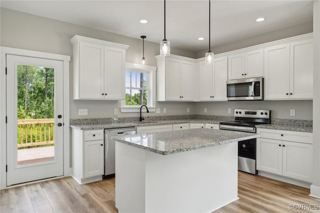 kitchen featuring appliances with stainless steel finishes, white cabinetry, and a kitchen island