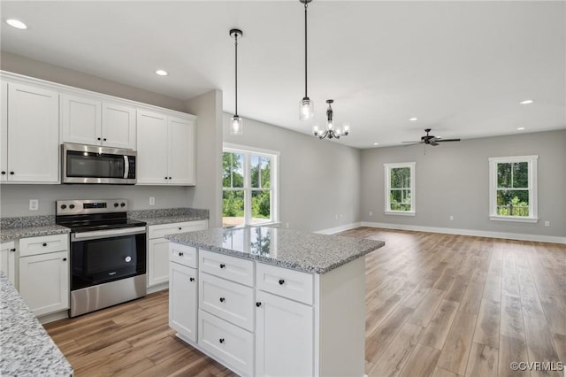 kitchen featuring plenty of natural light, ceiling fan, white cabinetry, and stainless steel appliances