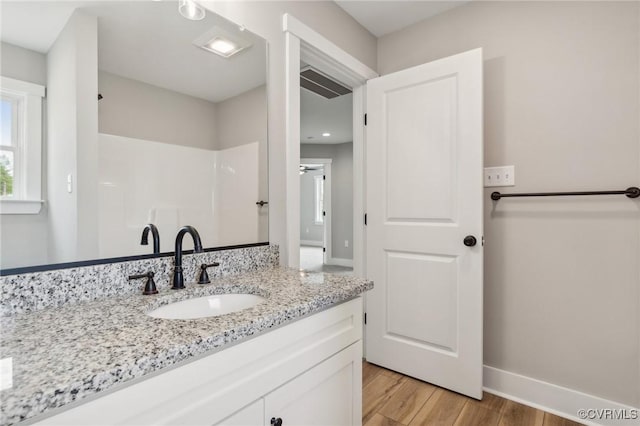 bathroom featuring hardwood / wood-style flooring, vanity, and a shower