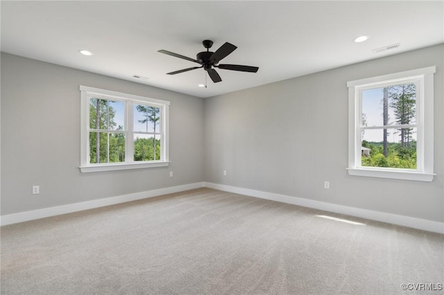 carpeted spare room with ceiling fan and a healthy amount of sunlight