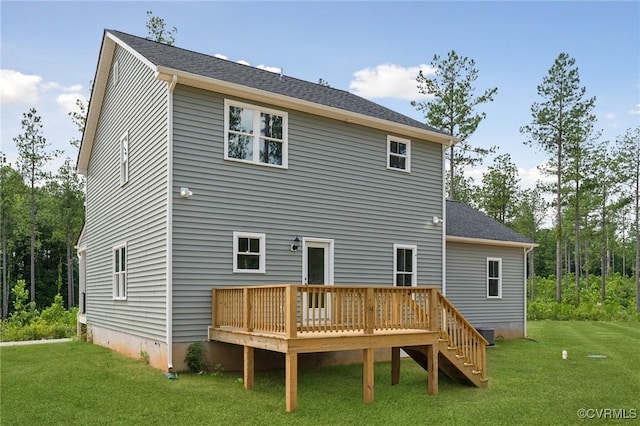 rear view of property with a deck and a lawn