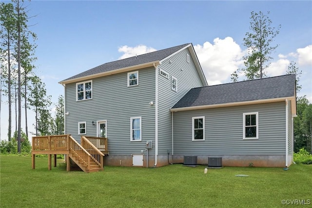 back of property with a wooden deck, a yard, and central AC