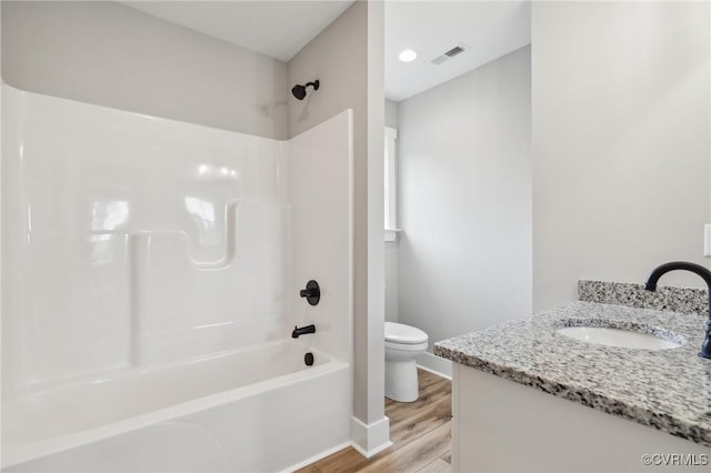 full bathroom with hardwood / wood-style floors, vanity, toilet, and shower / bathing tub combination