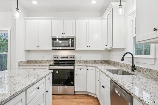 2467 Judes Ferry Rd, Powhatan, VA 23139 - kitchen featuring white cabinets, a sink, light wood-type flooring, appliances with stainless steel finishes, and hanging light fixtures