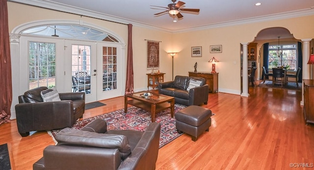 living room featuring wood finished floors, french doors, arched walkways, ceiling fan, and ornate columns