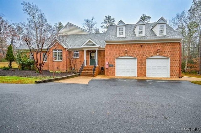 view of front of home with brick siding, an attached garage, and aphalt driveway