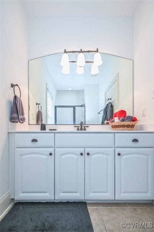 bathroom with an enclosed shower, vanity, and tile patterned flooring