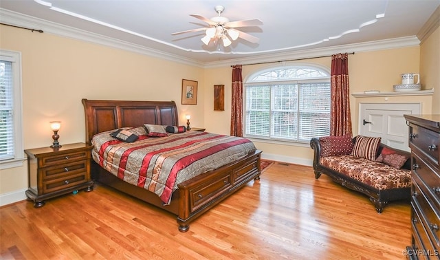 bedroom featuring a ceiling fan, baseboards, light wood-style floors, and crown molding