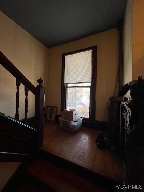 living area with hardwood / wood-style flooring and stairway