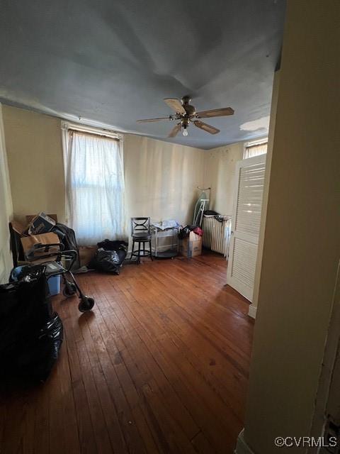 miscellaneous room with wood-type flooring, a ceiling fan, and radiator