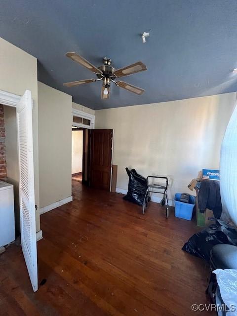 interior space featuring a ceiling fan, baseboards, and wood finished floors