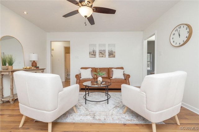 living room featuring hardwood / wood-style floors and ceiling fan